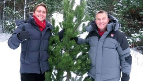 Bradley and Barney Walsh standing in the snow, holding a Christmas tree
