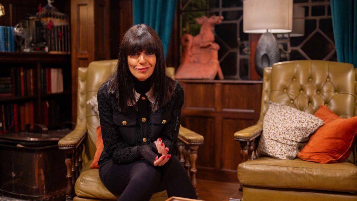 The Traitors host Claudia Winkleman sitting in the castle